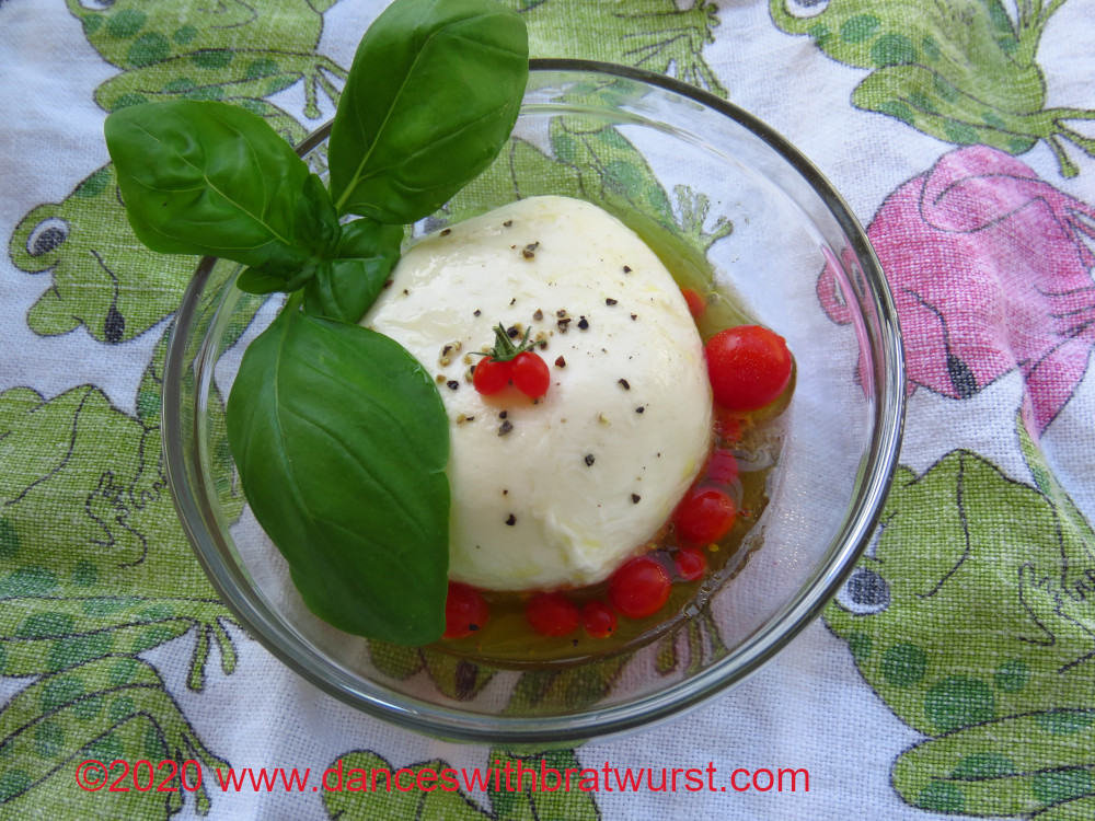 A caprese salat made with a very large mozzarella ball.